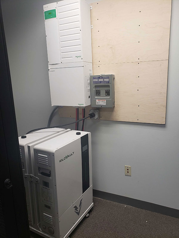 two KiloVault HAB lithium solar batteries and a XW Pro inverter mounted on a wall