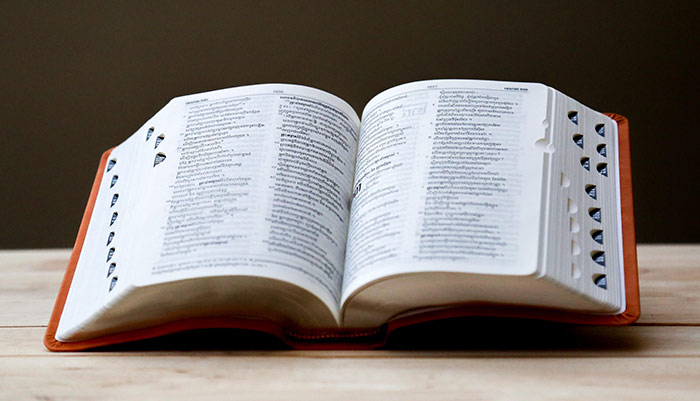 an open dictionary placed on a wood table